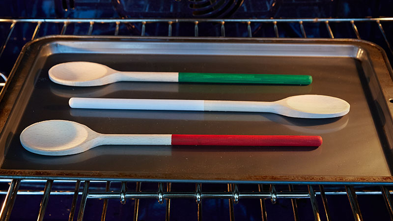 Wooden spoons on a cookie sheet in the oven