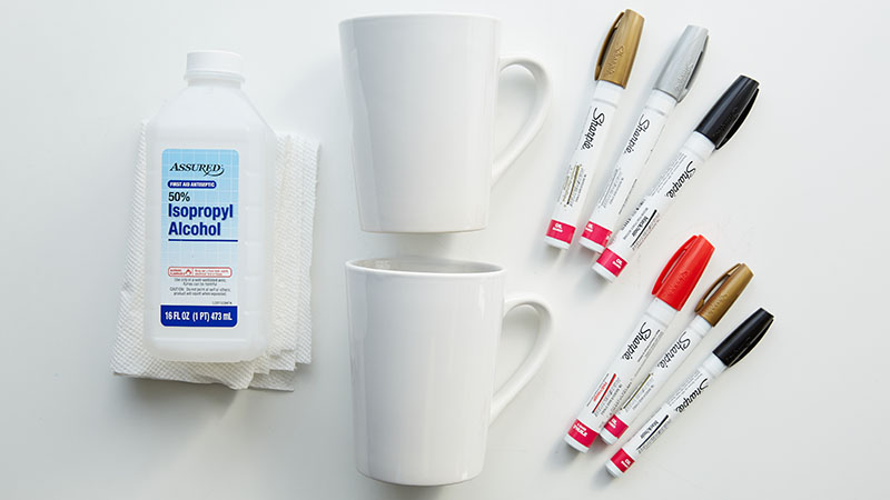 Rubbing alcohol, white ceramic mugs, paint pens