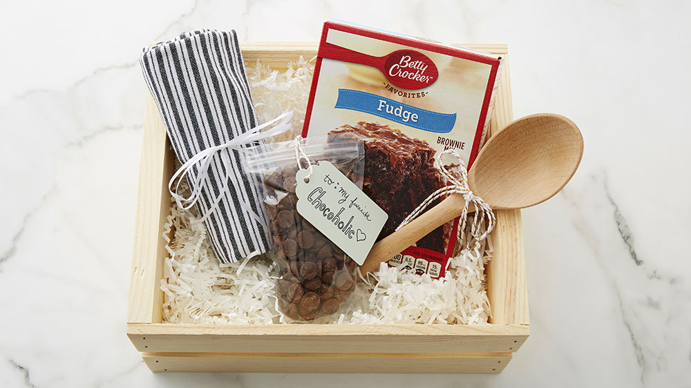 brownies gift basket with brownie mix, wooden spoon, chocolate chips and kitchen towel