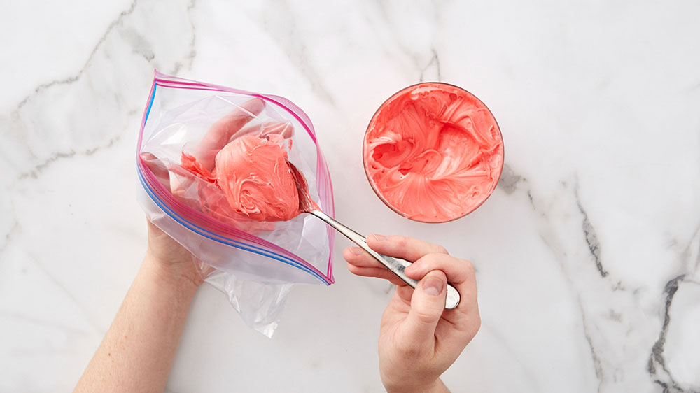 spooning frosting into a ziploc bag