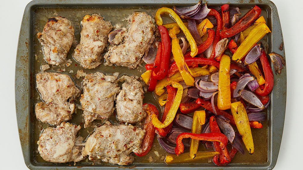 Baked chicken, peppers and onions on a sheet pan