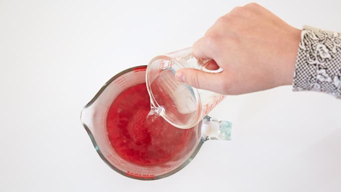 Combine jello powder and boiling water in a liquid measuring cup.