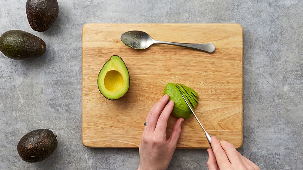 slide a spoon between the peel and the flesh, then turn it cut side down onto a cutting board