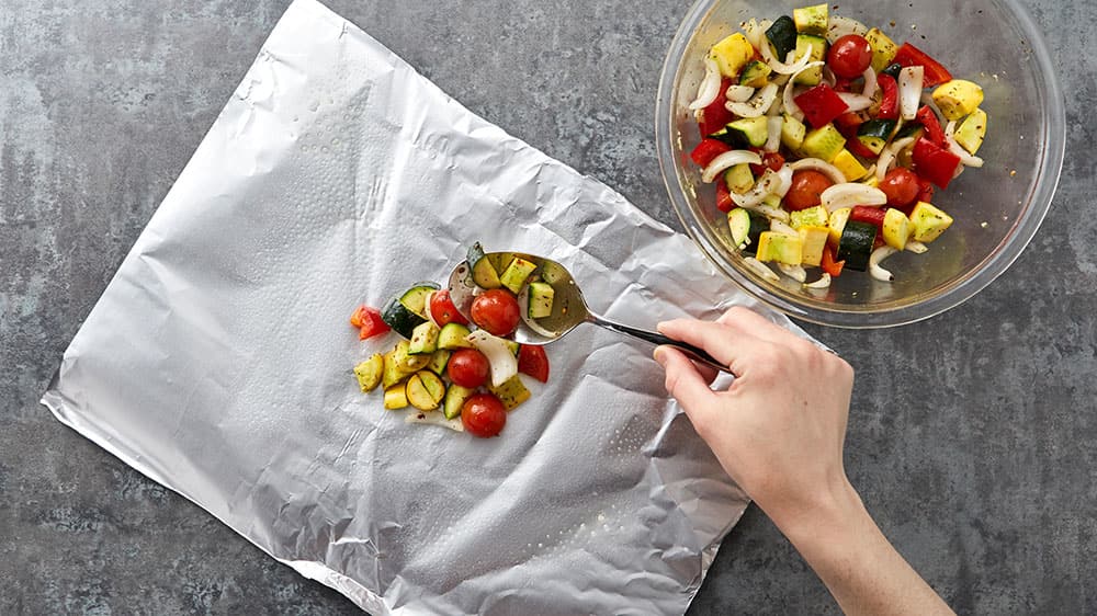 spooning veggie mixture onto foil