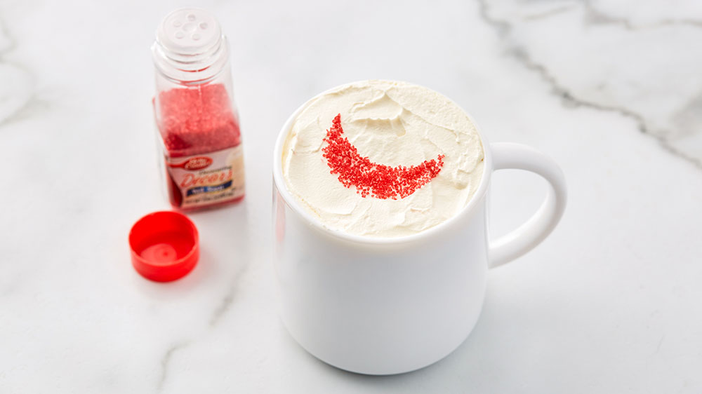 bottle of red sprinkles and cup with moon design on top