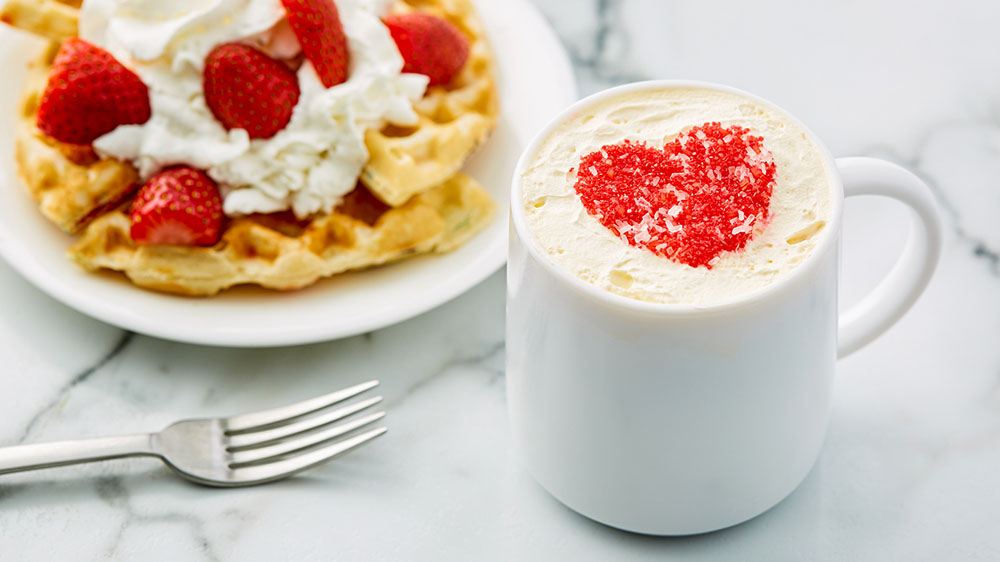 plate of waffles and cup of latte with heart made of sprinkles on top