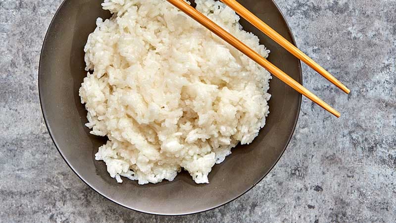 Hands cooking sticky rice with pot and rice steamer, traditional