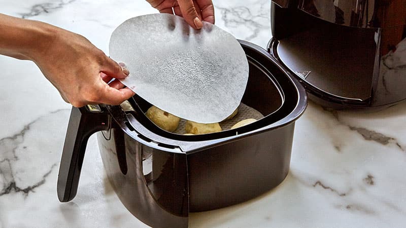 place biscuits on bottom and another piece of parchment on top