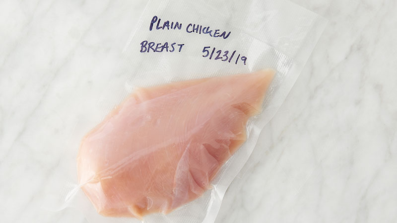 Raw chicken breast in a vacuum sealed plastic bag