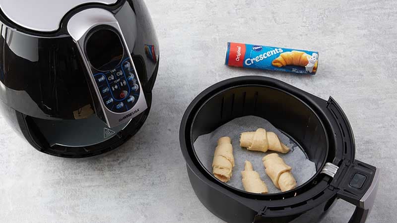 Place 4 crescent rolls on parchment in air fryer basket.