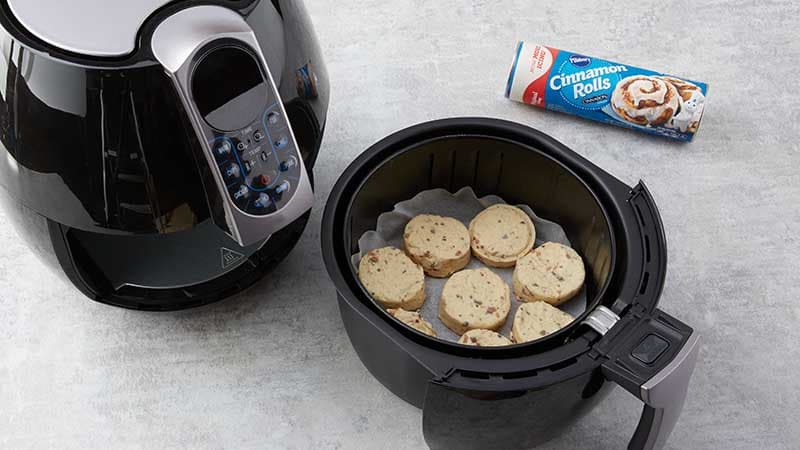 Place cinnamon rolls on parchment in air fryer basket  with cinnamon topping side down.